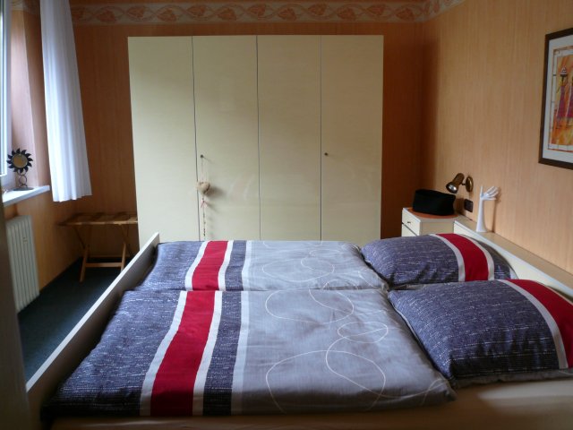 Geräumiges, helles Schlafzimmer mit Doppelbett und großem Kleiderschrank.